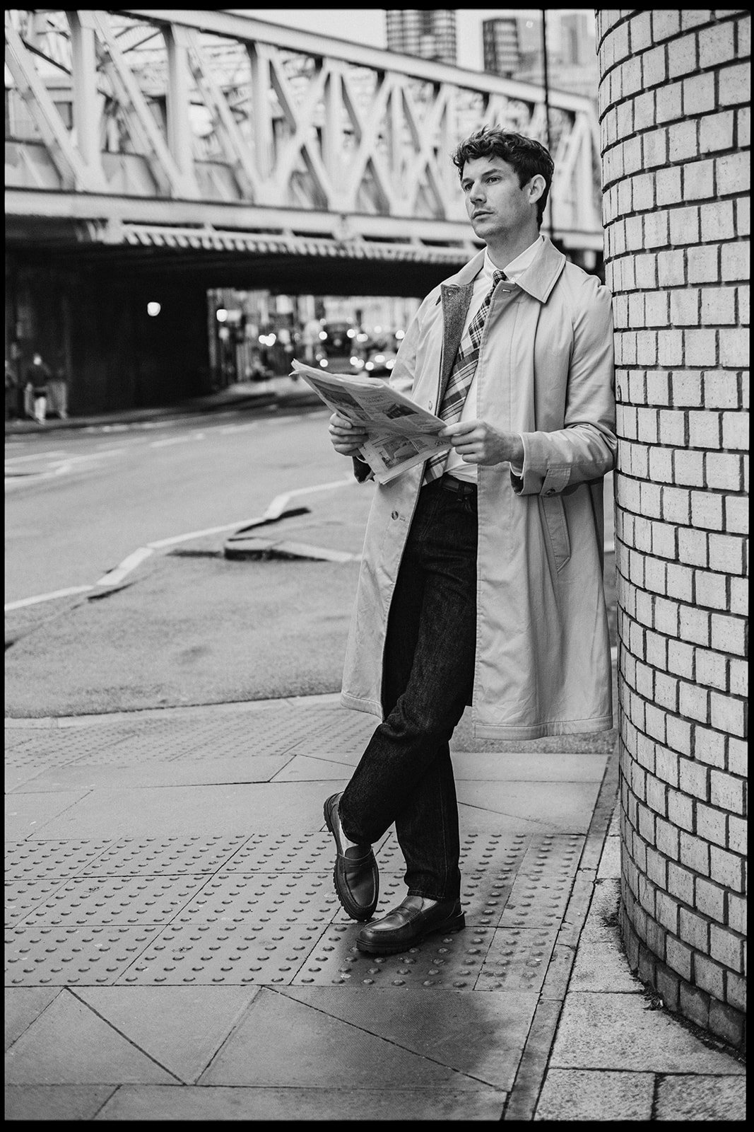 Homme lisant un journal dans la rue à Londres, portant des chaussures en cuir Pied de Biche.